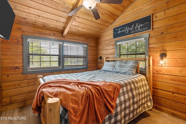 bedroom with lofted ceiling with beams, wood ceiling, and wooden walls