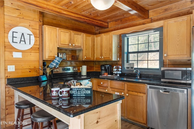 kitchen featuring stainless steel appliances, beamed ceiling, sink, wood walls, and wooden ceiling