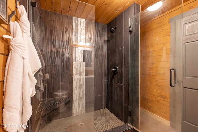 bathroom featuring toilet, an enclosed shower, wood ceiling, and wood walls