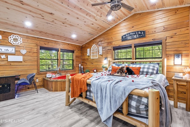 bedroom with lofted ceiling, wood walls, ceiling fan, wooden ceiling, and light hardwood / wood-style flooring