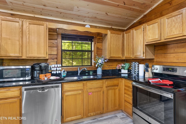 kitchen with appliances with stainless steel finishes, dark stone counters, sink, vaulted ceiling, and wooden ceiling