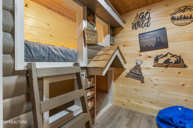 interior space with wood ceiling, hardwood / wood-style flooring, and wooden walls