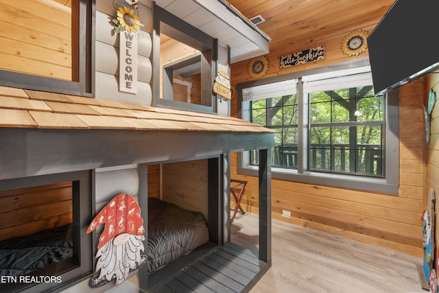 interior space with hardwood / wood-style flooring, wooden ceiling, and wooden walls