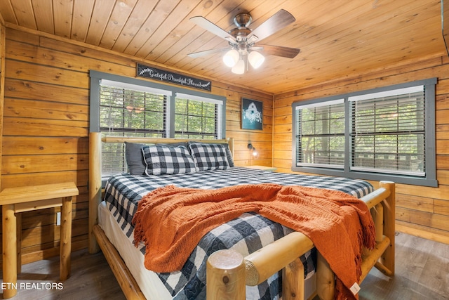 bedroom featuring ceiling fan, wood ceiling, hardwood / wood-style floors, and wooden walls