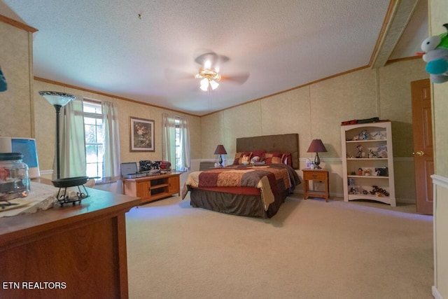 carpeted bedroom with ceiling fan, crown molding, and a textured ceiling