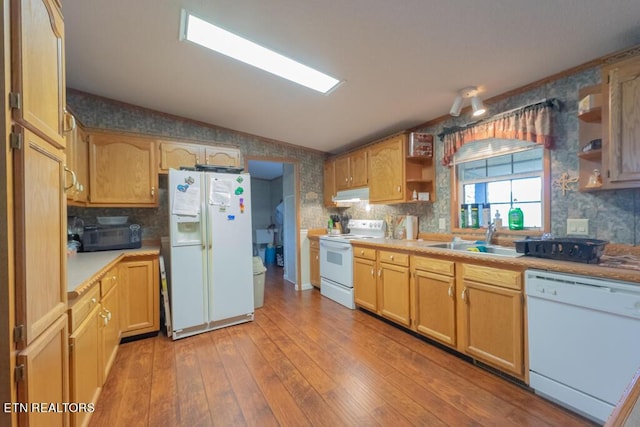 kitchen featuring sink, backsplash, lofted ceiling, white appliances, and light wood-type flooring