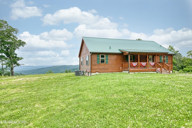 log cabin with a front yard, covered porch, and cooling unit