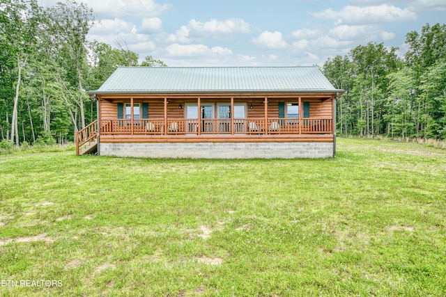 rear view of property featuring a lawn