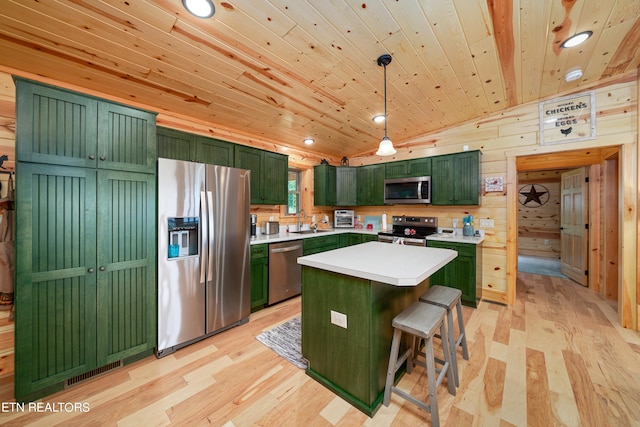 kitchen with pendant lighting, appliances with stainless steel finishes, a center island, wooden walls, and wooden ceiling