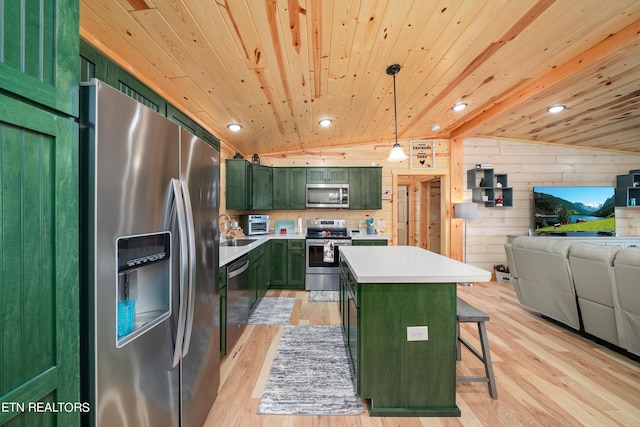 kitchen featuring hanging light fixtures, green cabinets, stainless steel appliances, and a center island