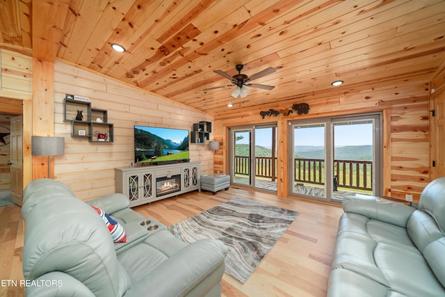 living room with wooden walls, light hardwood / wood-style floors, vaulted ceiling, ceiling fan, and wooden ceiling