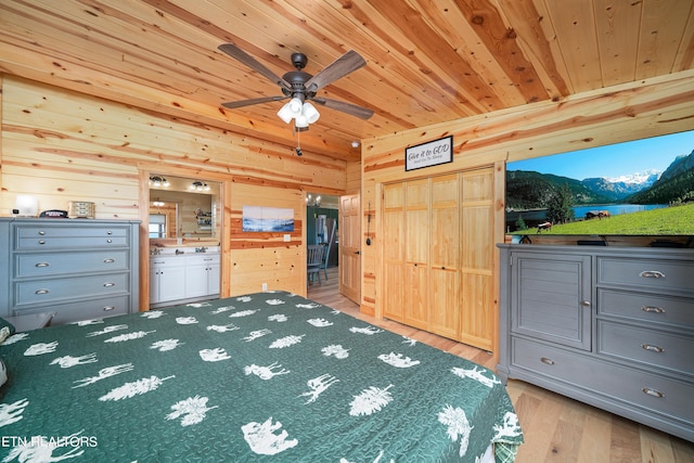 unfurnished bedroom with ensuite bath, light wood-type flooring, wood walls, and wooden ceiling