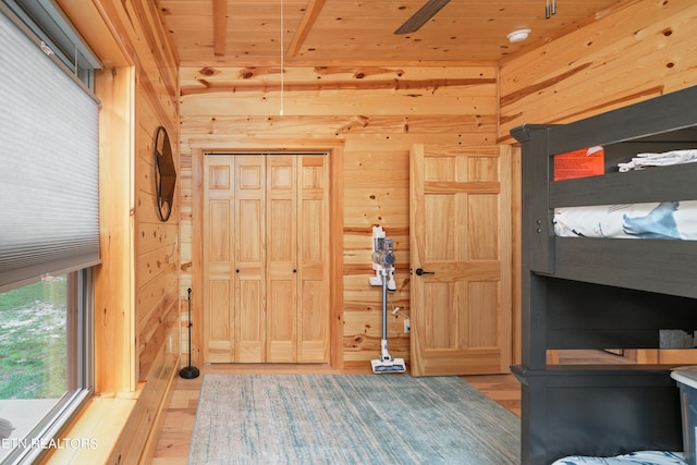 bedroom with hardwood / wood-style floors, a closet, wood walls, and wooden ceiling