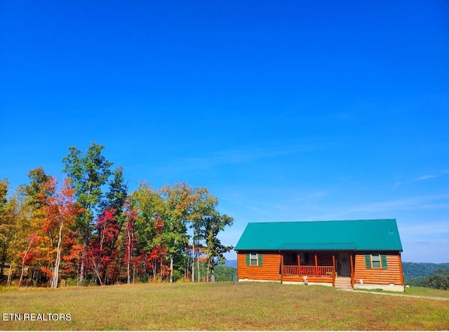 cabin with a front lawn and a porch