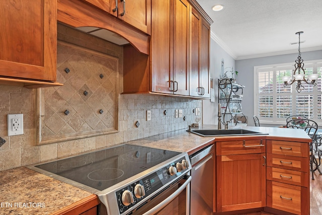 kitchen featuring sink, crown molding, stainless steel appliances, and a notable chandelier