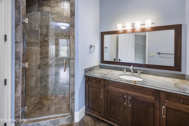 bathroom featuring a shower with door, tile patterned flooring, and vanity