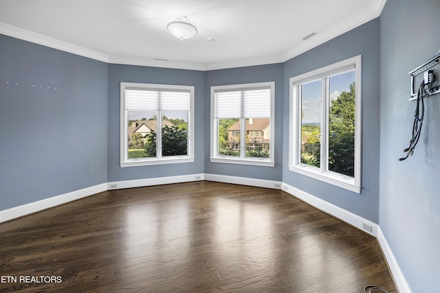 empty room with a healthy amount of sunlight, dark wood-type flooring, and crown molding