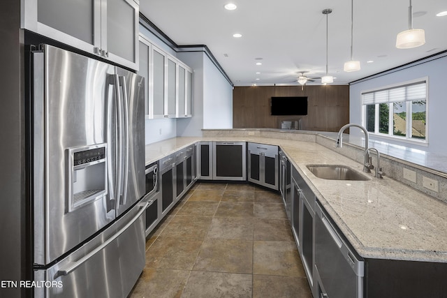 kitchen featuring light stone counters, kitchen peninsula, stainless steel appliances, ceiling fan, and sink