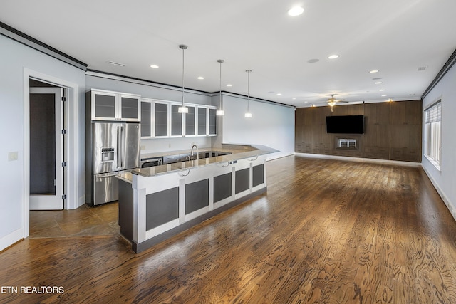 kitchen with hanging light fixtures, ceiling fan, ornamental molding, stainless steel refrigerator with ice dispenser, and stone countertops