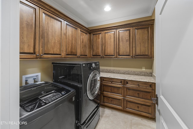 washroom featuring washer and dryer, cabinets, ornamental molding, and light tile patterned floors