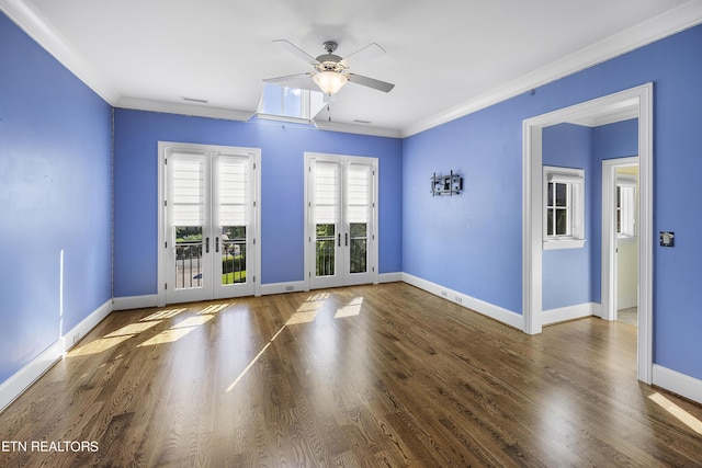 empty room with ornamental molding, dark wood-type flooring, ceiling fan, and french doors