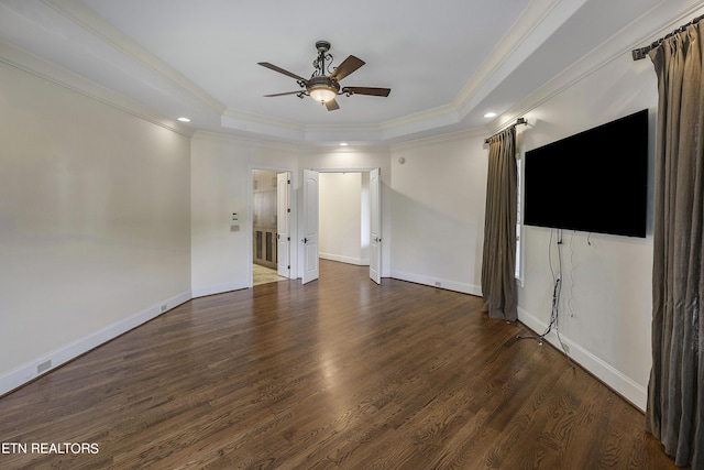 unfurnished living room featuring ceiling fan, ornamental molding, a tray ceiling, and dark wood-type flooring