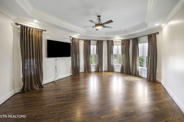 unfurnished room with ceiling fan, dark wood-type flooring, crown molding, and a tray ceiling