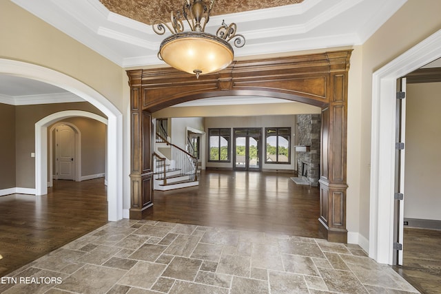 interior space with ornamental molding and a raised ceiling