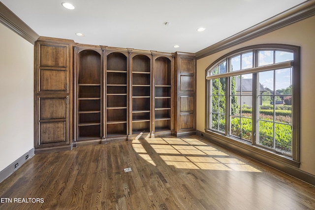 empty room featuring hardwood / wood-style floors, a wealth of natural light, and crown molding