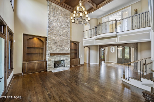 unfurnished living room with a high ceiling, coffered ceiling, french doors, and a stone fireplace