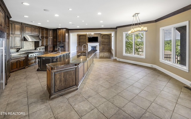 kitchen with stainless steel appliances, decorative backsplash, dark brown cabinets, and an island with sink