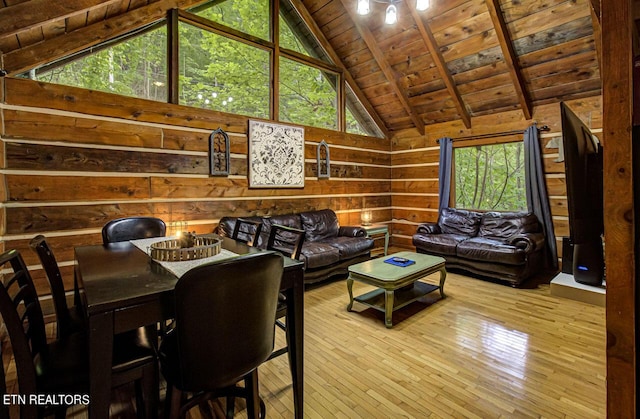 living room featuring light wood-type flooring, wooden walls, a healthy amount of sunlight, wooden ceiling, and vaulted ceiling with beams