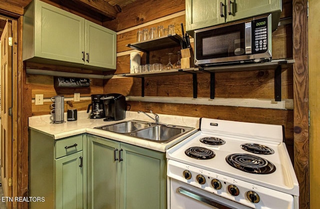 kitchen featuring electric stove, wooden walls, sink, and green cabinets