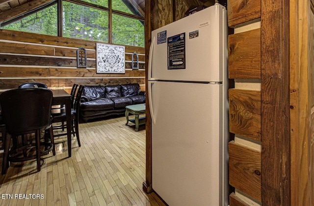 kitchen featuring hardwood / wood-style floors, white fridge, and vaulted ceiling