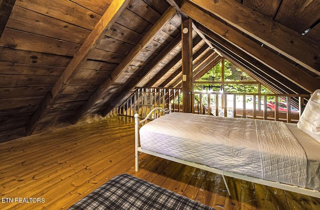 unfurnished bedroom with hardwood / wood-style floors, lofted ceiling with beams, and wood ceiling