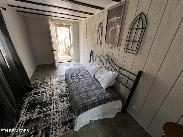 bedroom featuring wooden walls