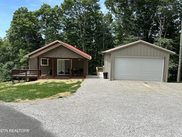 view of front of property featuring a garage, an outbuilding, and a wooden deck