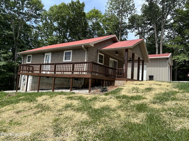 back of property with a lawn, ceiling fan, and a deck