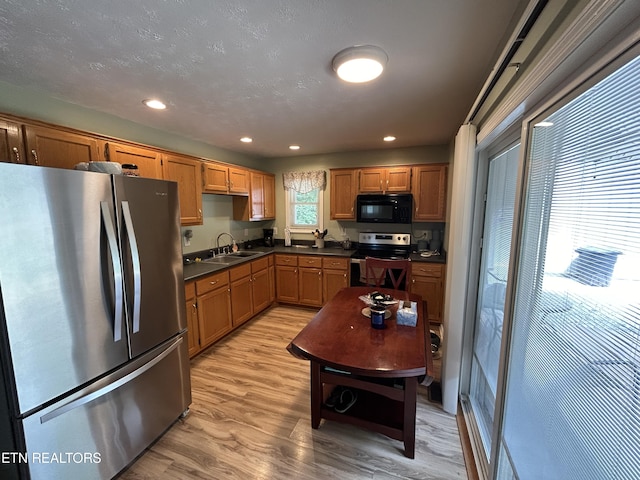 kitchen with sink, appliances with stainless steel finishes, and light wood-type flooring