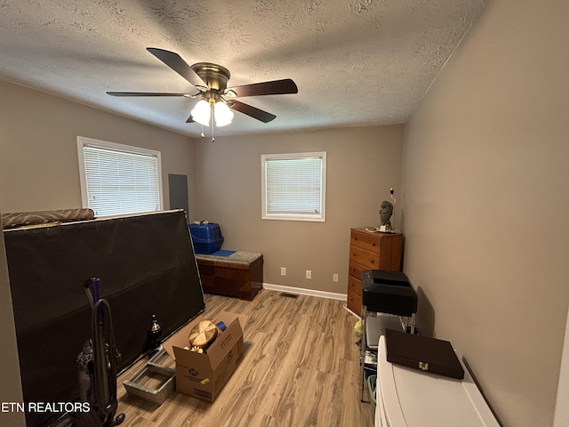 miscellaneous room with light hardwood / wood-style floors, a textured ceiling, and ceiling fan