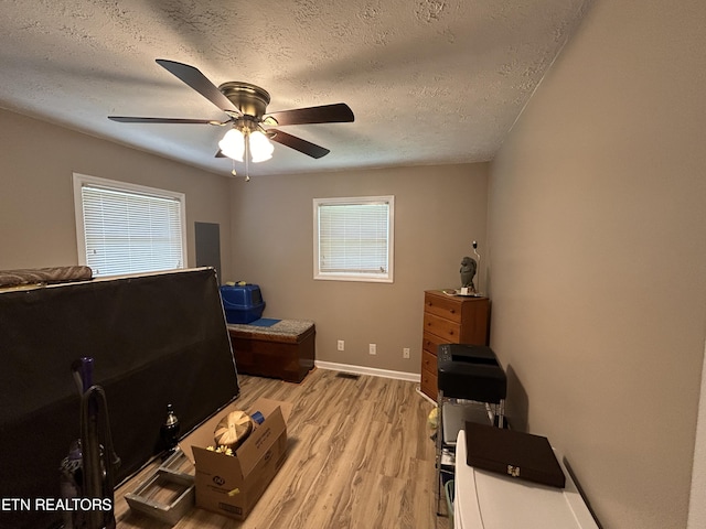 office with ceiling fan, a healthy amount of sunlight, a textured ceiling, and light hardwood / wood-style flooring