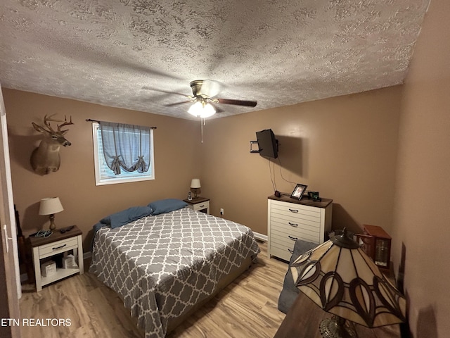 bedroom featuring a textured ceiling, ceiling fan, and light hardwood / wood-style floors