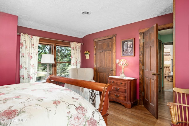 bedroom with light wood-type flooring and a textured ceiling