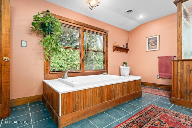 bathroom featuring vaulted ceiling, tile patterned flooring, and a bathtub