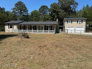 view of front of home with a front lawn, a porch, and a garage