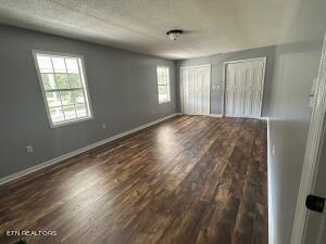 unfurnished room featuring a textured ceiling and dark hardwood / wood-style floors