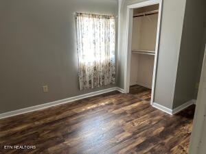 unfurnished bedroom featuring dark hardwood / wood-style flooring and a closet