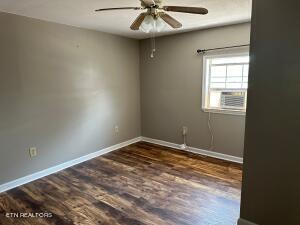 spare room with ceiling fan and dark hardwood / wood-style flooring