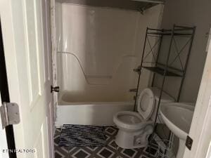 bathroom featuring shower / bathing tub combination and toilet