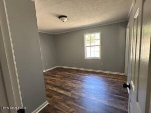 unfurnished room featuring ornamental molding, a textured ceiling, and dark wood-type flooring